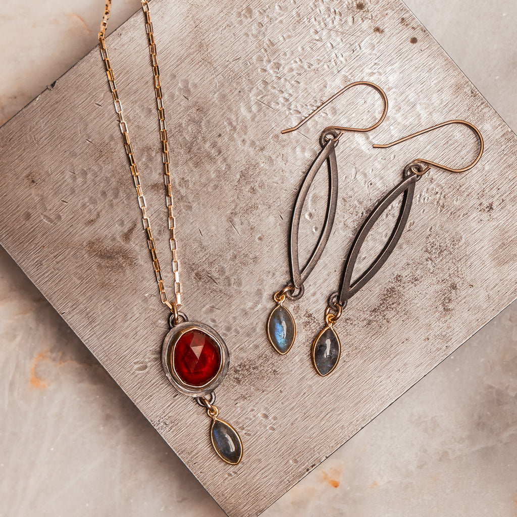Artisan handcrafted mixed metal pendant necklace with deep red garnet and labradorite drop.