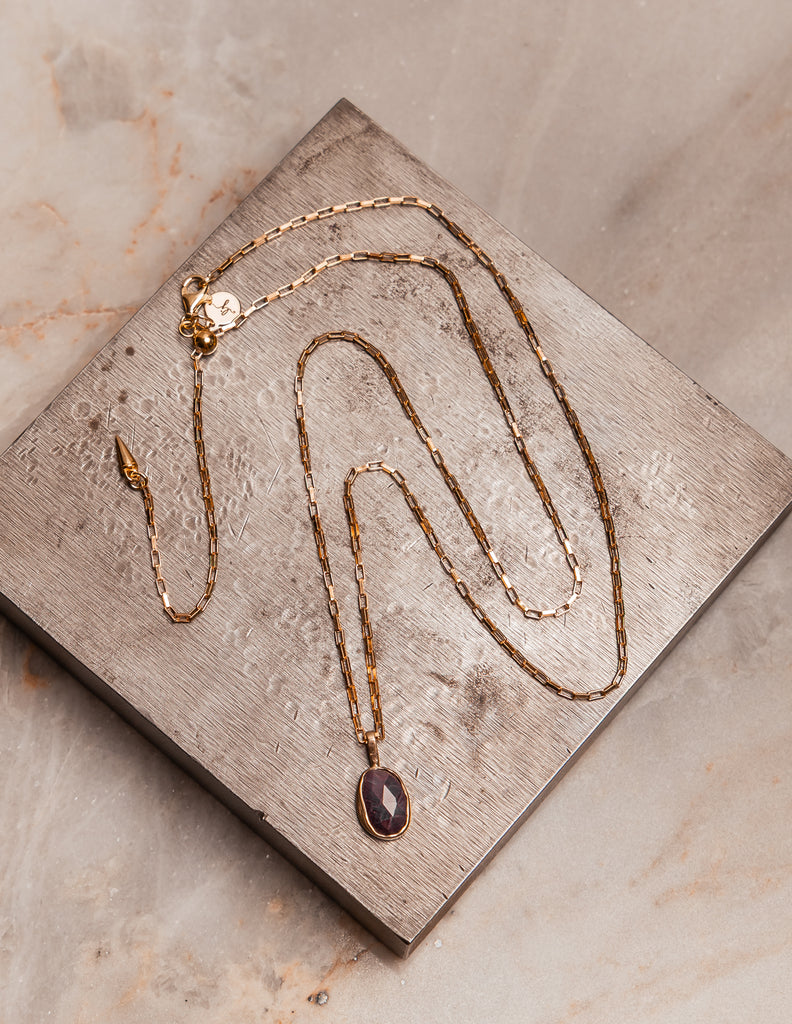 Camille Necklace with an organic-shaped ruby pendant in a 14k gold bezel and sterling silver setting.