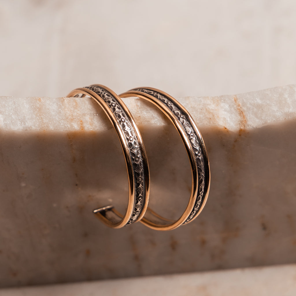 Modern gold and sterling silver hoop earrings with artisan detail and timeless sophistication.