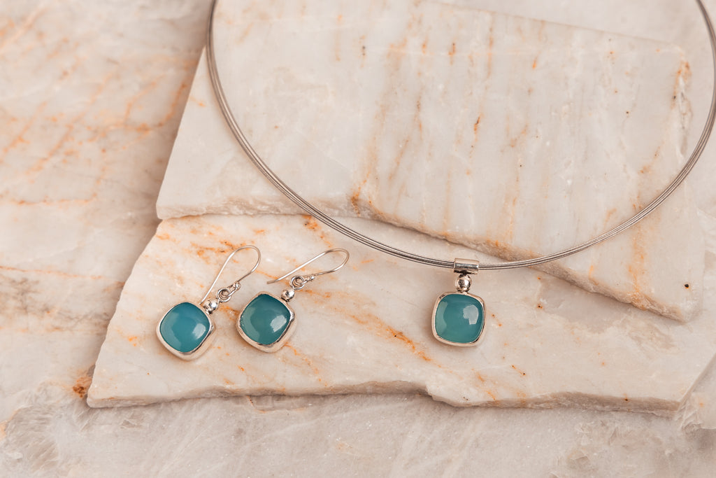Handcrafted sterling silver earrings with vivid cyan paraiba tourmaline stones.