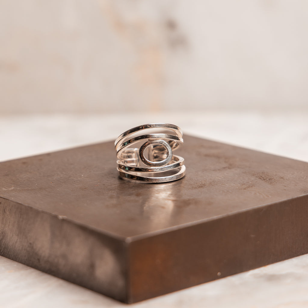 Contemporary sterling silver ring with wide-band profile and handcrafted finish, adjustable for sizes 7–10