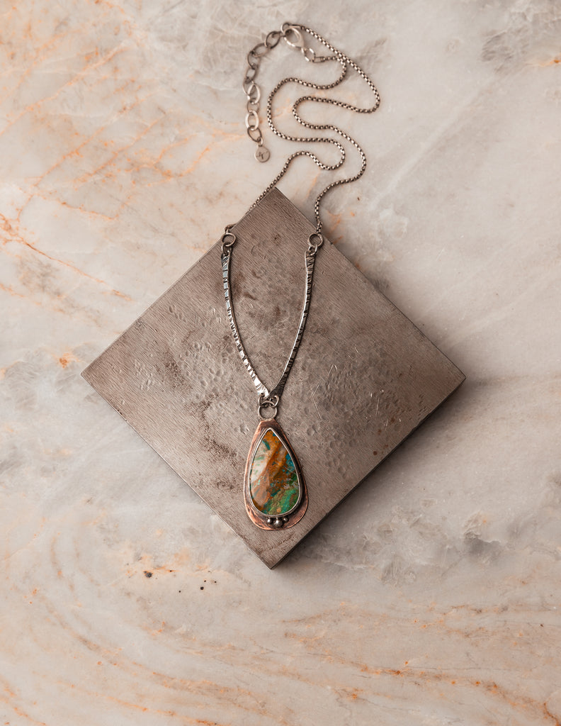 Capturing the essence of rare beauty in a pendant: Peruvian Blue Opal meets mixed metals. #HandcraftedJewelry #OpalElegance