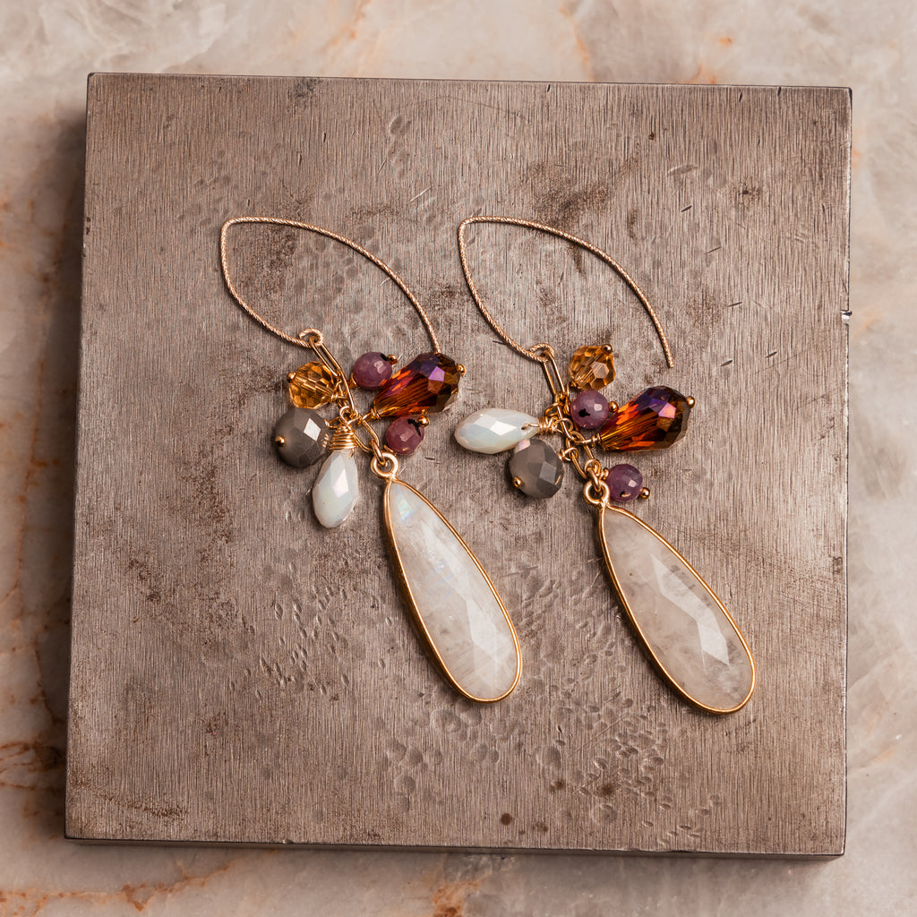 Jewel-toned artisan earrings – rainbow moonstone, ruby, and faceted beads in gold setting.