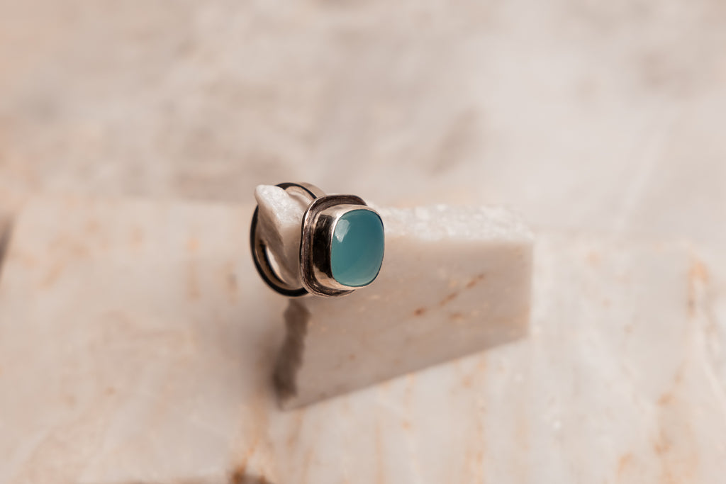 Luxurious statement ring pairing polished silver with luminous Brazilian Paraiba agate in modern square cut
