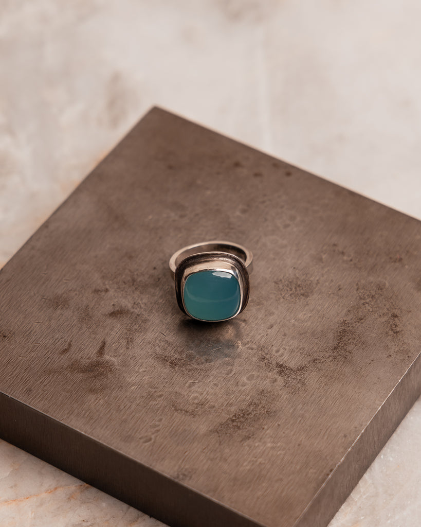 Luxurious statement ring pairing polished silver with luminous Brazilian Paraiba agate in modern square cut