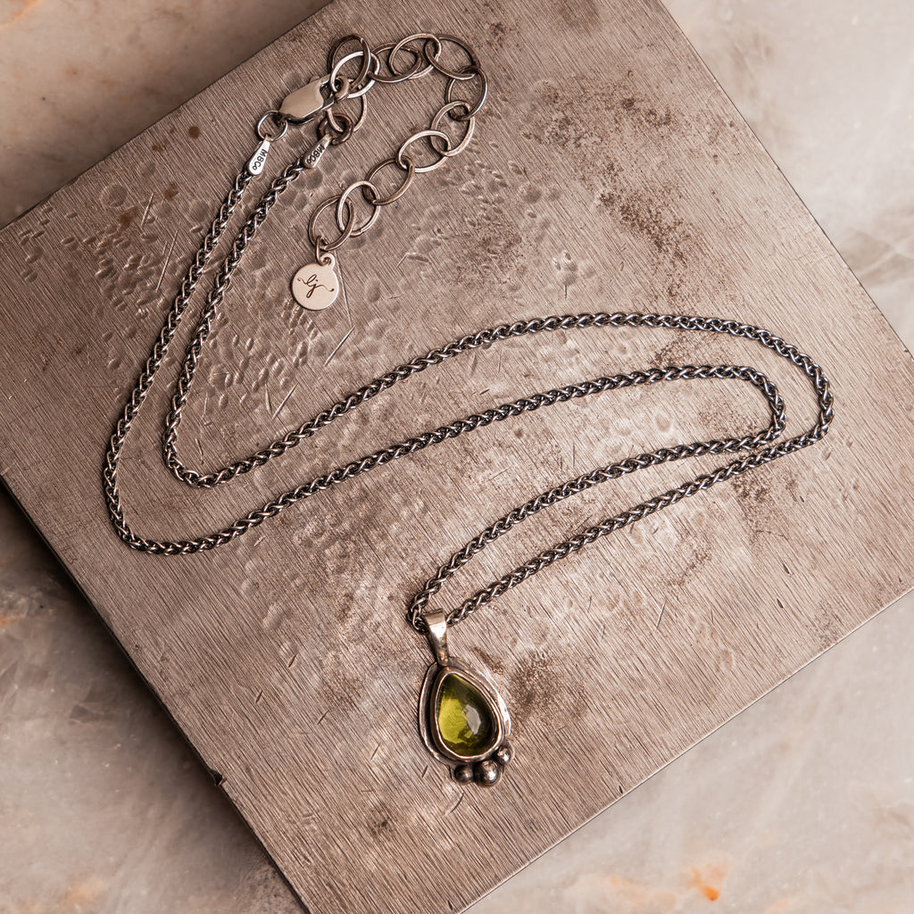 Nature-inspired Lily Necklace with green peridot and hand-forged silver details