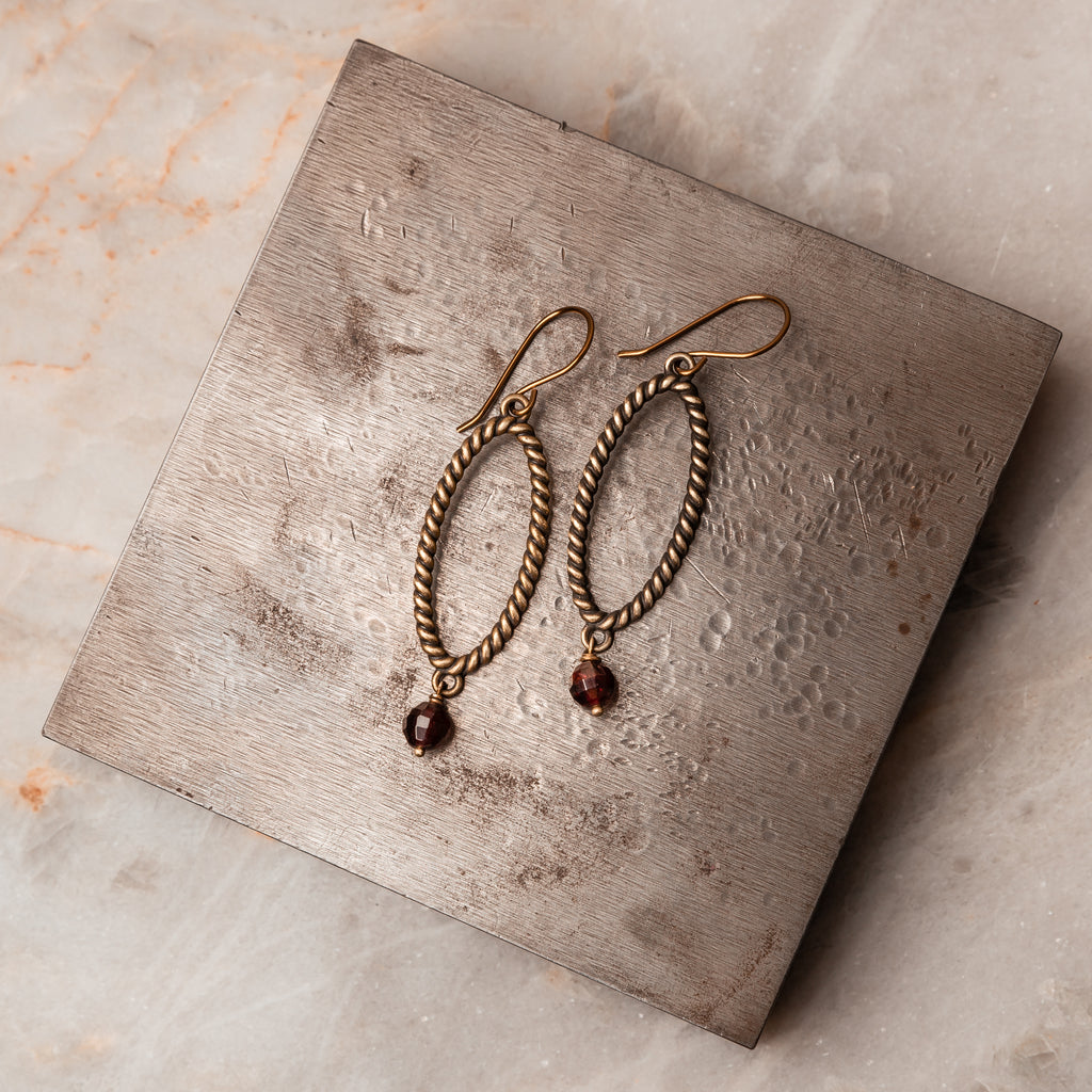 Timeless Elegance - Michaela Earrings featuring vintage-style twisted wire hoops and faceted garnet gemstone. Perfect lightweight accessory