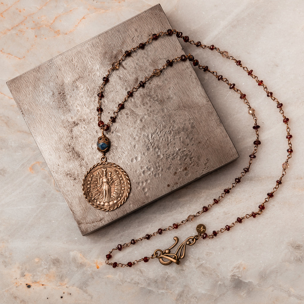 Mary, Jesus, St. Michael Medallion Necklace - Michaela Garnet Beaded Necklace with faceted garnet gemstones. Antique brass accent and 24" length for versatile styling