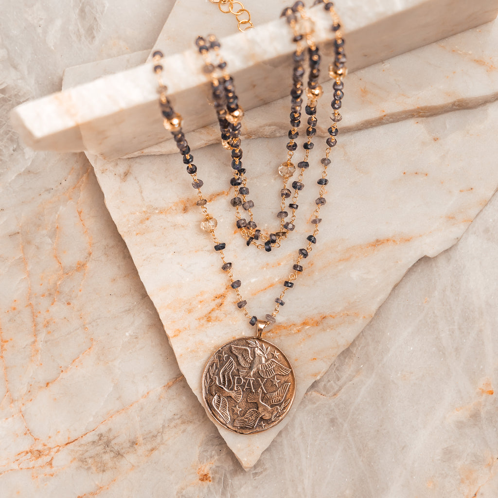 Artisan necklace – universal peace medal pendant with iolite gemstone strands.