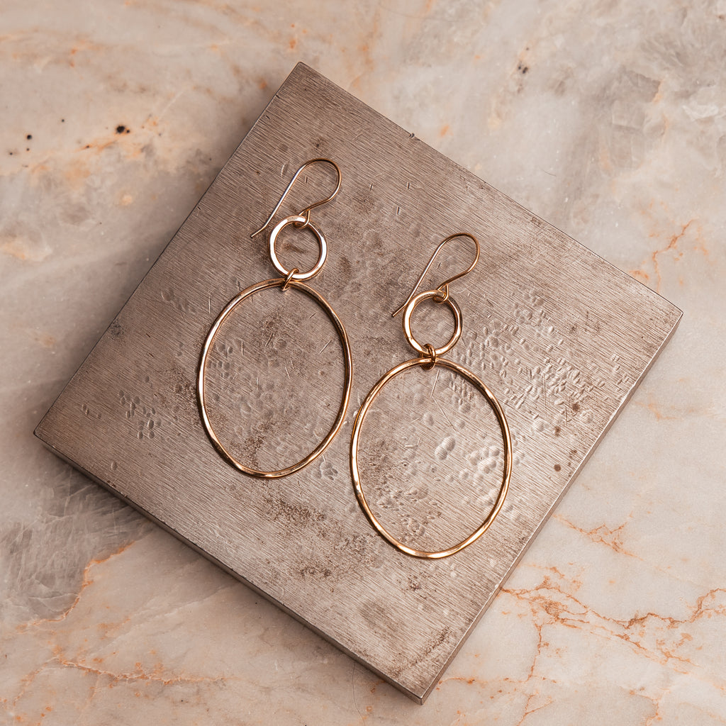 Modern artisan earrings with connected hoops and hand-hammered finish, ideal for casual and evening looks