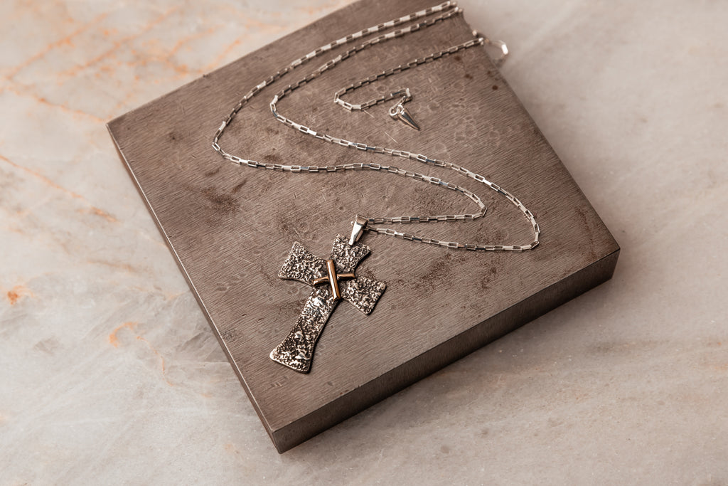 Symbol of Peace - Salome Cross Necklace, adjustable up to 22 inches, with rugged texture and solid gold accent. Crafted for enduring beauty and meaningful gifting