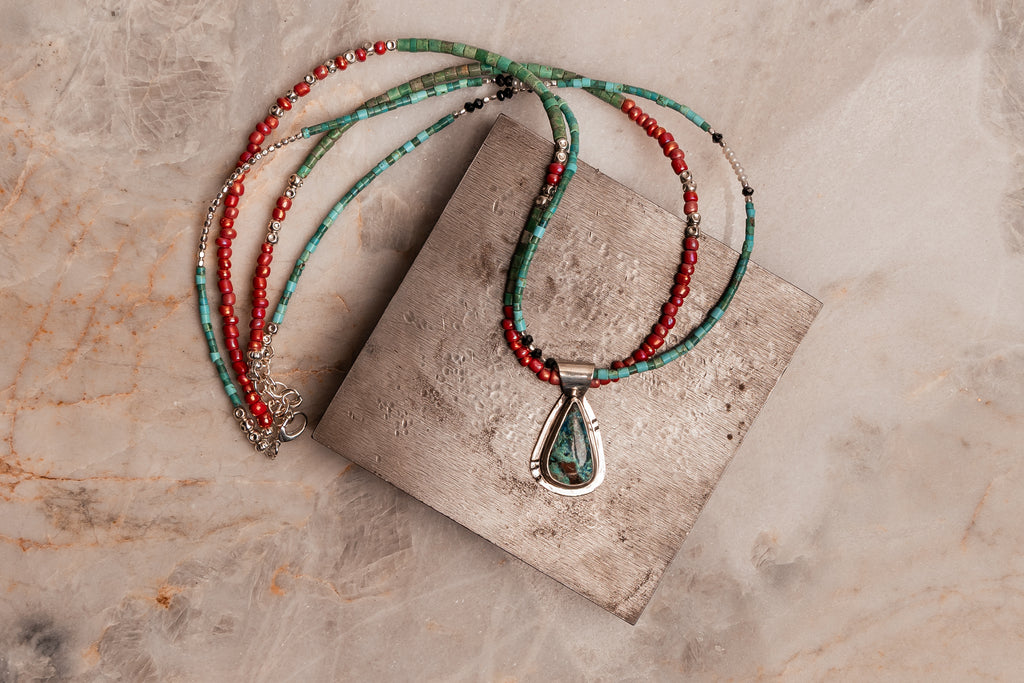 Handcrafted luxury necklace featuring sterling silver and a double strand of vibrant artisan beads and freshwater pearls.