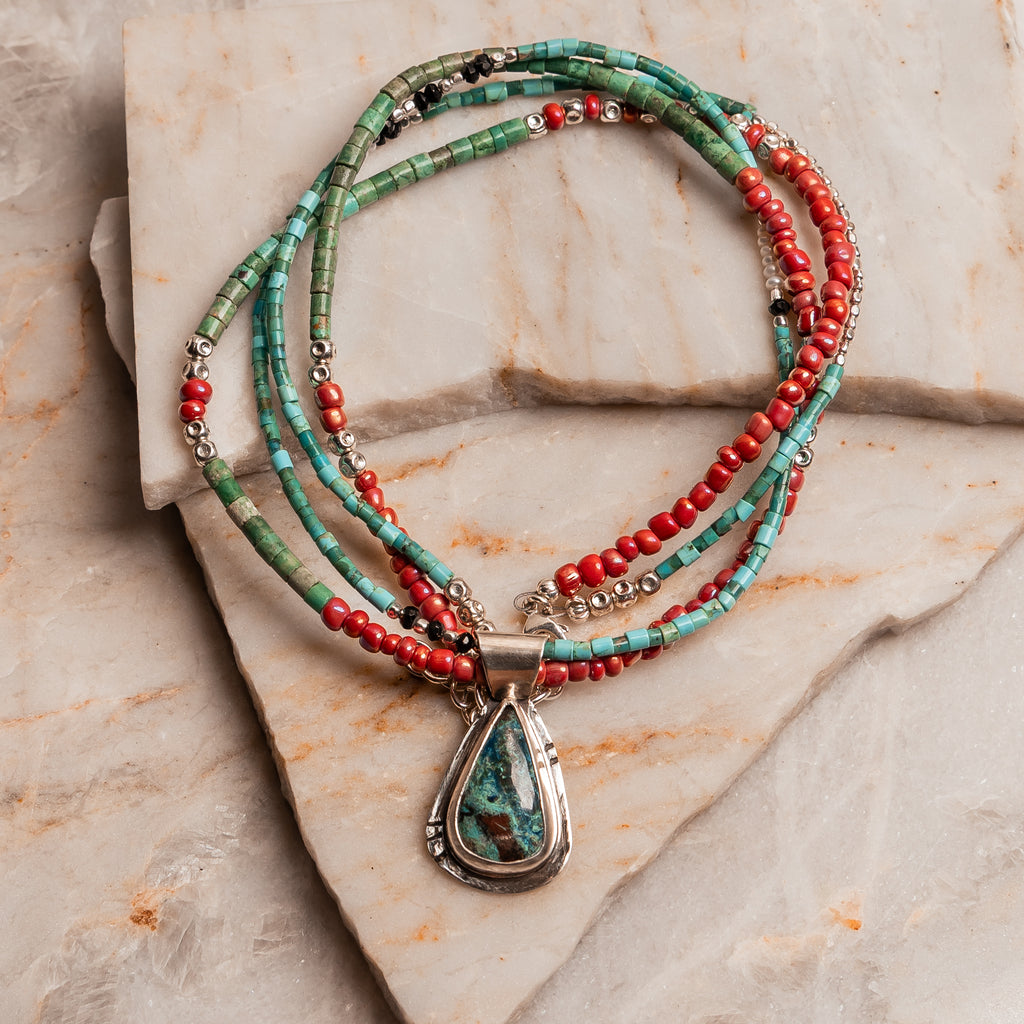 Boho chic gemstone statement necklace with shattuckite pendant and artisan beaded strands in turquoise and pink.