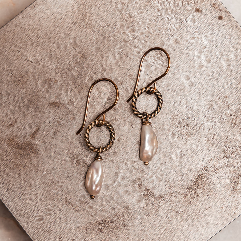 Rustic pearl drop earrings with luminous keshi pearls and antique brass accents, perfect for boho chic style.
