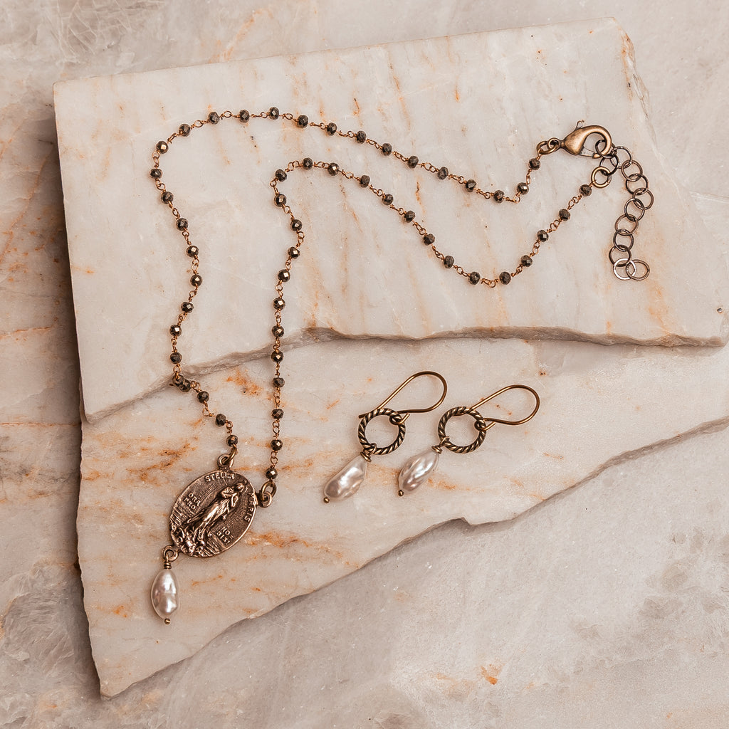 Luminous freshwater pearl earrings with rustic brass wire hoops, ideal for timeless, handmade jewelry lovers.