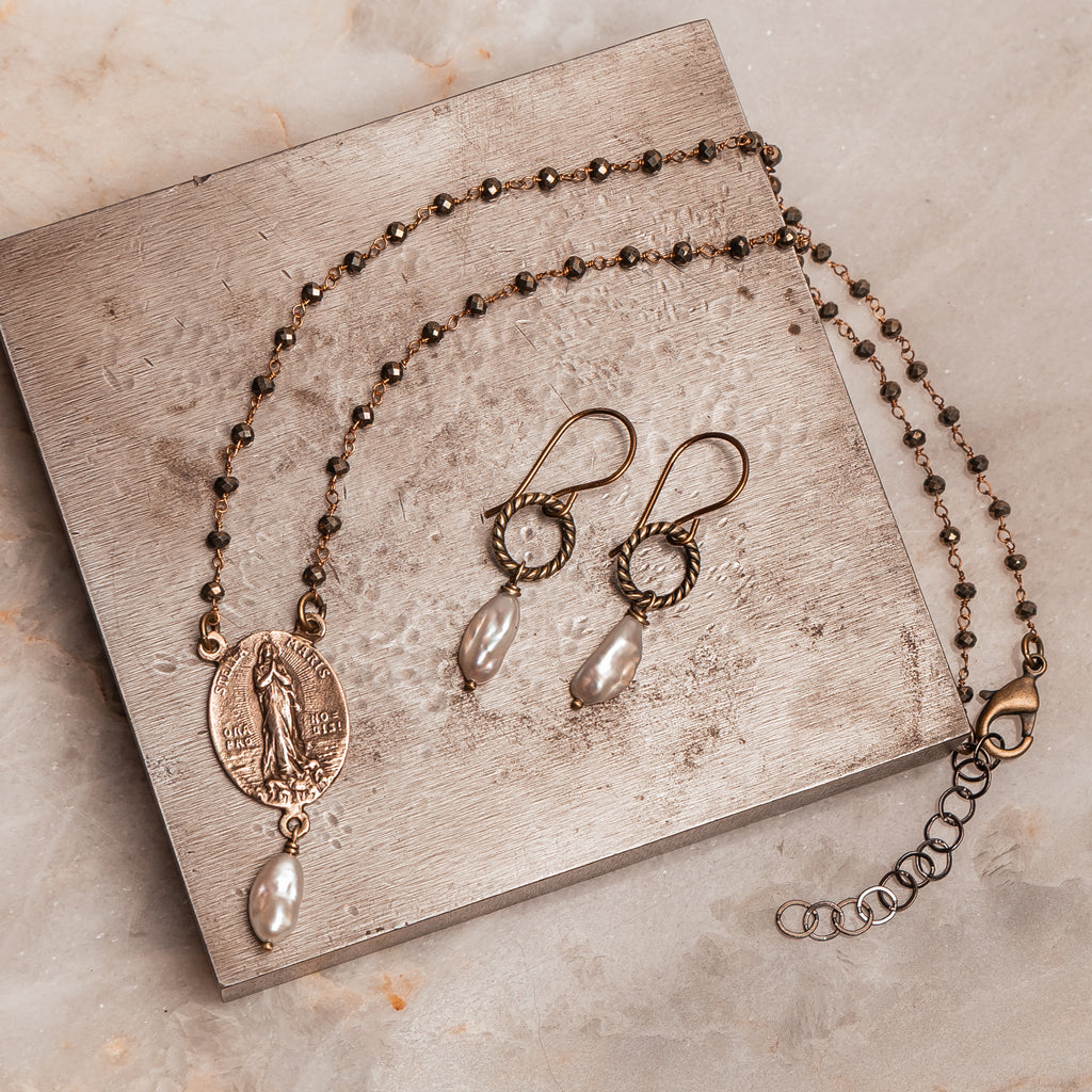 Luxury religious necklace featuring Stella Maris icon in bronze, artisan-crafted with high-end pyrite accents and pearl charm.