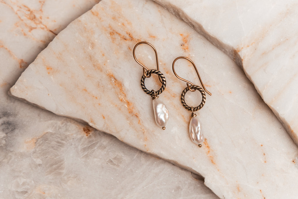 Elegant artisan pearl earrings hanging from French ear wires, a beautiful gift for women who love handcrafted jewelry.