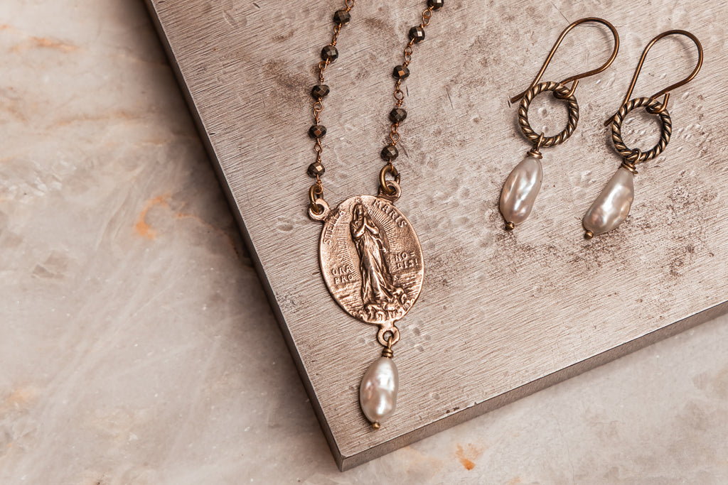 Mary necklace with bronze Stella Maris medal, pyrite gemstone chain, and freshwater pearl drop—perfect for layered looks.

