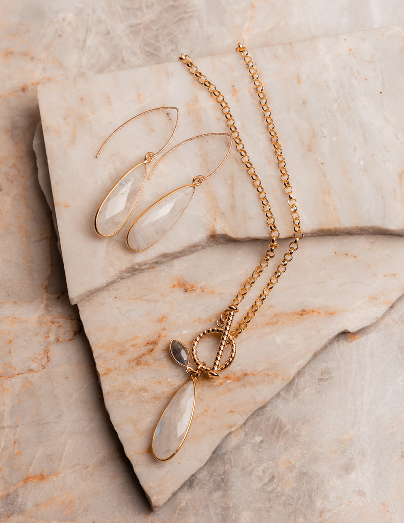 Contemporary gold necklace design featuring teardrop rainbow moonstone and front toggle closure